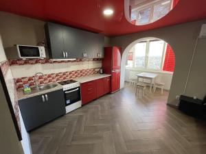 文尼察Studio apartment on Vatutina的厨房配有红色橱柜、水槽和桌子