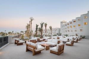 赫尔格达Serry Beach Resort的庭院设有白色的沙发、桌子和棕榈树