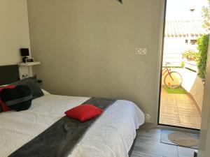 阿格德角Naturiste Heliovillage Villa de Standing的一间卧室配有一张红色枕头的床