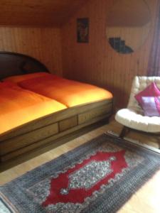 StaldenriedStaldenried Ferienwohnung的一间卧室配有一张床、地毯和椅子