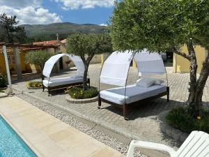 维拉·雷阿尔Quinta da Menina Guest House的游泳池畔的几张床