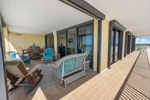 奥兰治比奇Summer House 901A by ALBVR - Gorgeous Beachfront Corner Condo with Incredible Views的门廊配有椅子和桌子