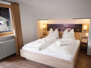 柯尼希斯湖畔舍瑙加尼太阳星酒店的卧室配有一张带白色床单和枕头的大床。