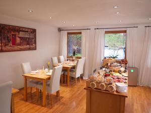 柯尼希斯湖畔舍瑙加尼太阳星酒店的用餐室配有桌椅和餐桌,