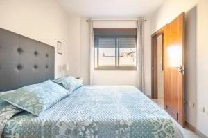 圣伊西德罗Casa Ivonne - San Isidro的一间卧室配有一张带蓝色棉被的床和窗户。
