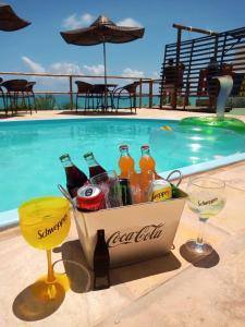马拉戈日Pousada Alto do Cruzeiro的游泳池旁的饮料篮和玻璃杯