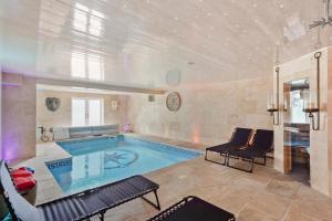 法利5 Star Lux Coastal Gem - Indoor Heated Pool - Pets的一个带椅子和沙发的大型游泳池