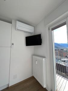 奥斯塔Settimo Cielo Apartment Aosta CIR 0199的白色的客房设有平面电视和窗户。