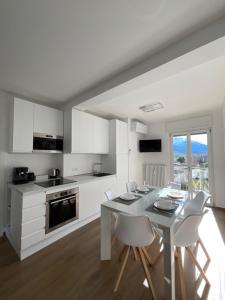奥斯塔Settimo Cielo Apartment Aosta CIR 0199的白色的厨房配有白色的桌子和椅子