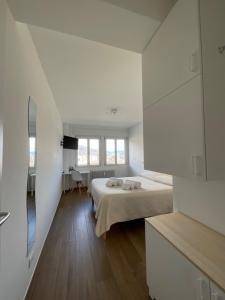 奥斯塔Settimo Cielo Apartment Aosta CIR 0199的白色的客房配有床和镜子