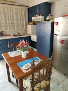 卡梅纳维洛拉Spitaki mou的厨房配有木桌和蓝色橱柜。