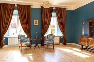 SkangaļiSkangaļu muiža的蓝色的客房设有两把椅子、一张桌子和窗户。