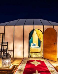 梅尔祖卡Luxury Local Camp的一间铺有红地毯的帐篷内的卧室