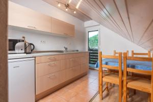 博希尼Apartments Žnidar的厨房配有木制橱柜和桌椅