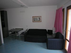 奥尔比亚Residence Le Terrazze的客厅配有沙发和桌子