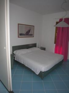 奥尔比亚Residence Le Terrazze的卧室配有白色的床和粉红色窗帘