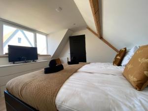 德科赫The island life beach house 2的一间卧室设有一张大床和一台平面电视。