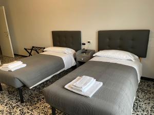 基亚拉瓦莱La Locomotiva的两张位于酒店客房的床,配有毛巾