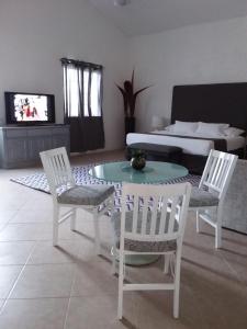 坎昆Junior suite Privada 7 min del Aeropuerto的客厅配有桌椅和沙发