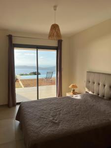 卡尔热斯Villa Cargese的一间卧室配有一张床,享有海景