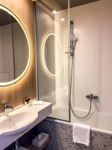维尔纽斯CONTI HOTEL VILNIUS, Conference Centre, Restaurant & Bar的一间带水槽和淋浴的浴室