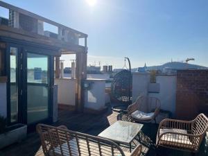 布达佩斯Charming studio shared rooftop terrace/Jacuzzi 360 view的阳台的天井配有桌椅