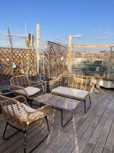 布达佩斯Charming studio shared rooftop terrace/Jacuzzi 360 view的海洋甲板上的三把椅子和一张桌子
