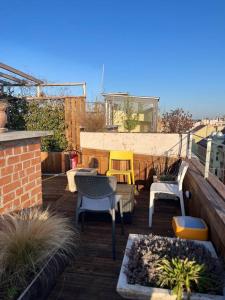 布达佩斯Charming studio shared rooftop terrace/Jacuzzi 360 view的阳台的天井配有桌椅