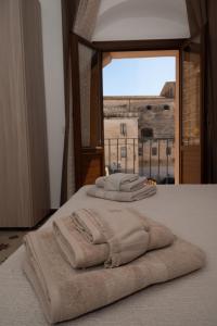 夏卡Giulietta Normanna的三条毛巾坐在带窗户的床上