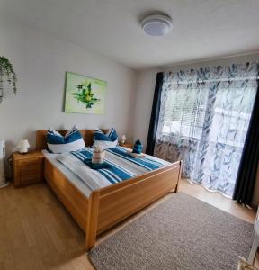 LavamündGästehaus Rettl的一间卧室配有一张带蓝色枕头的床和一扇窗户。
