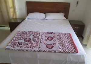 Jazīrat al ‘AwwāmīyahNile Paradise的床上有红白毯子
