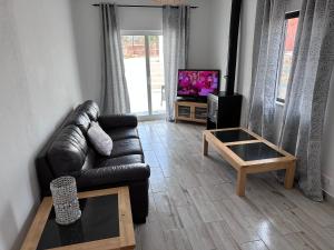 拉戈斯Casa Maria João的客厅配有真皮沙发和电视