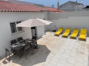 拉戈斯Casa Maria João的庭院配有桌椅和遮阳伞。