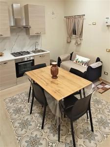 阿格里真托Sicilia bedda的厨房以及带木桌和椅子的用餐室。