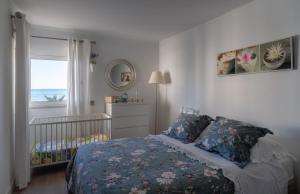 奎特里拉Apartamento Deluxe AM的一间卧室配有婴儿床和一张带窗户的床。