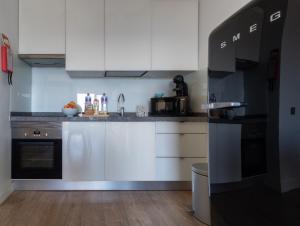 奎特里拉Apartamento Deluxe AM的厨房配有白色橱柜和黑色家电