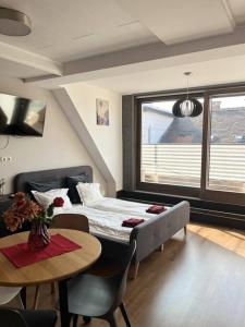 布达佩斯Sunny/stylish rooftop home/private balcony shared jacuzzi的一间卧室配有一张床、一张桌子和一个窗户。