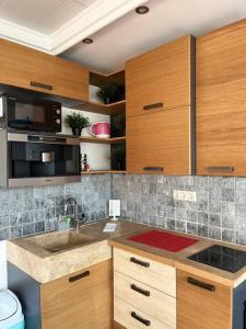 布达佩斯Sunny/stylish rooftop home/private balcony shared jacuzzi的一个带木制橱柜和水槽的厨房