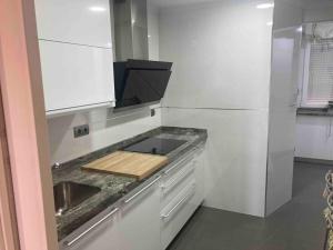 阿维拉Atico Avila的厨房配有带水槽的柜台和冰箱。