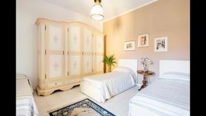 努奥罗B&B Maison Rosetta IUN-E4948的一间带两张床和梳妆台的卧室
