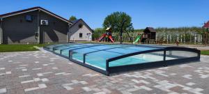TiszakanyárVillage Garden Family Guest House的一个带游乐场的玻璃泳池