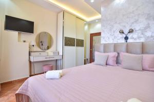佩特罗瓦纳莫鲁Beach House的卧室配有一张带紫色枕头的大型白色床。