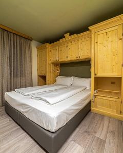 卡纳泽伊Chalet Margoni的一间卧室配有一张带木制橱柜的大床