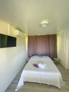 帕皮提Temana Airport Faa'a,Tahiti的卧室配有白色床和紫色床头板