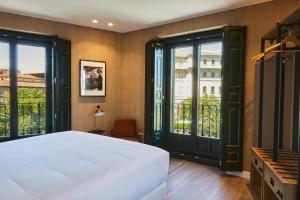 马德里LATROUPE Prado Hostel的卧室设有白色的床和大窗户