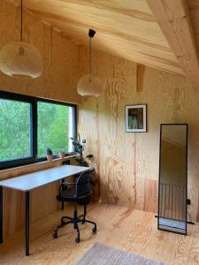 Domek na wzgórzu的一个带书桌和镜子的家庭办公室