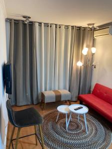 圣地亚哥阿莫布拉达斯蒙马特普罗维登公寓的客厅配有红色沙发和红色椅子