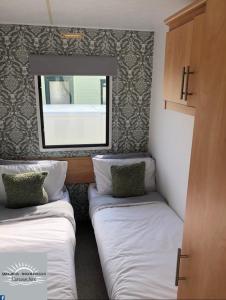 英戈尔德梅尔斯Skegness - Ingoldmells Caravan Hire的小房间设有两张床和镜子