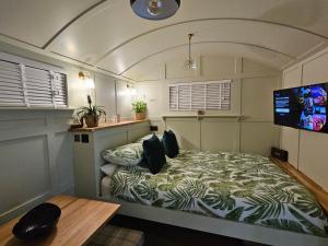 查尔伍德Gatwick Hideaway Hut的一间带一张床的卧室,位于带电视的客房内