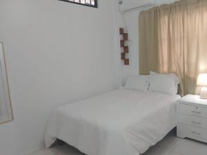 瓜亚基尔Comfortable 3-Bedroom Condo in Bellavista, Guayaquil的白色的卧室设有白色的床和窗户。